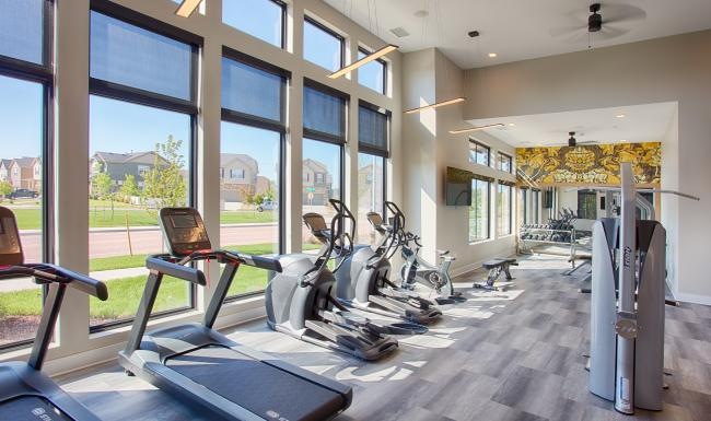 a room with exercise equipment and windows